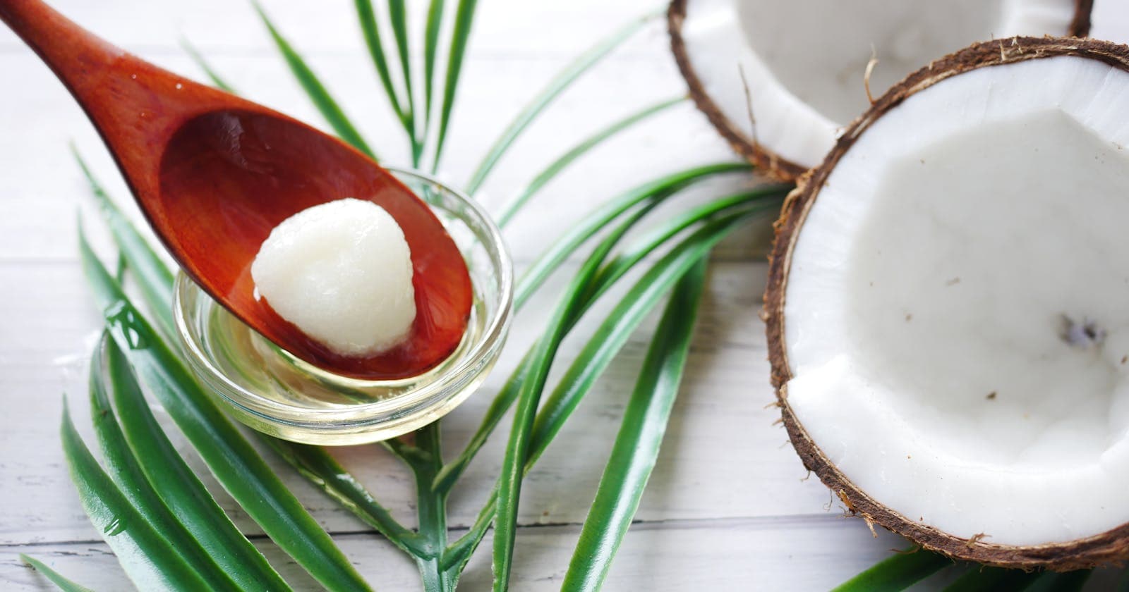 Coconut oil with palm leaves on a wooden spoon, cooling agents Pitta needs