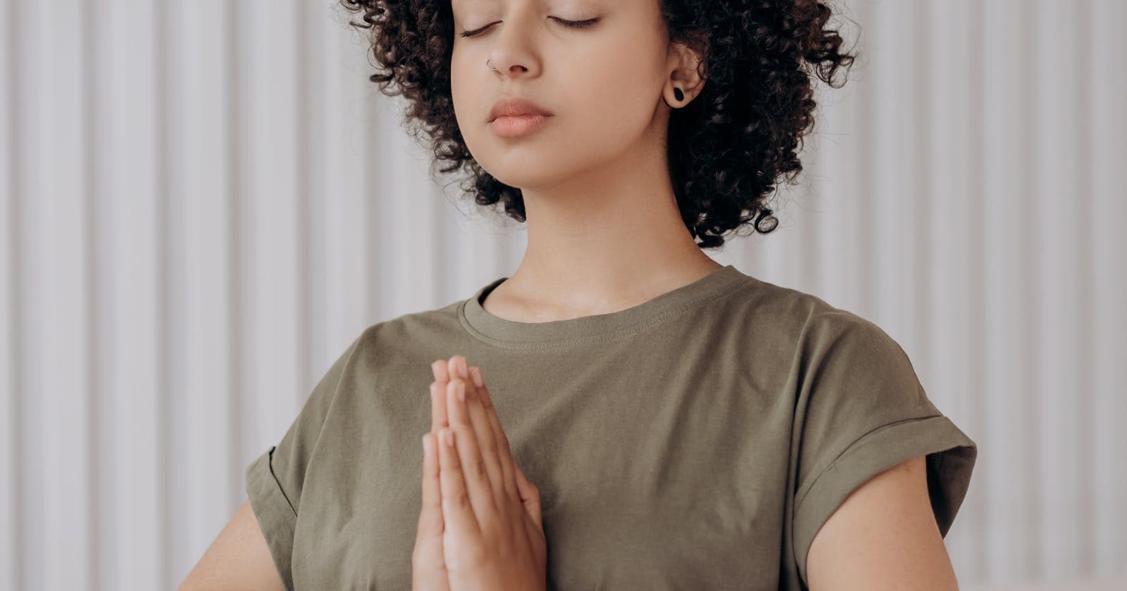 Young woman meditating with curly hair — the wellness apps people actually use