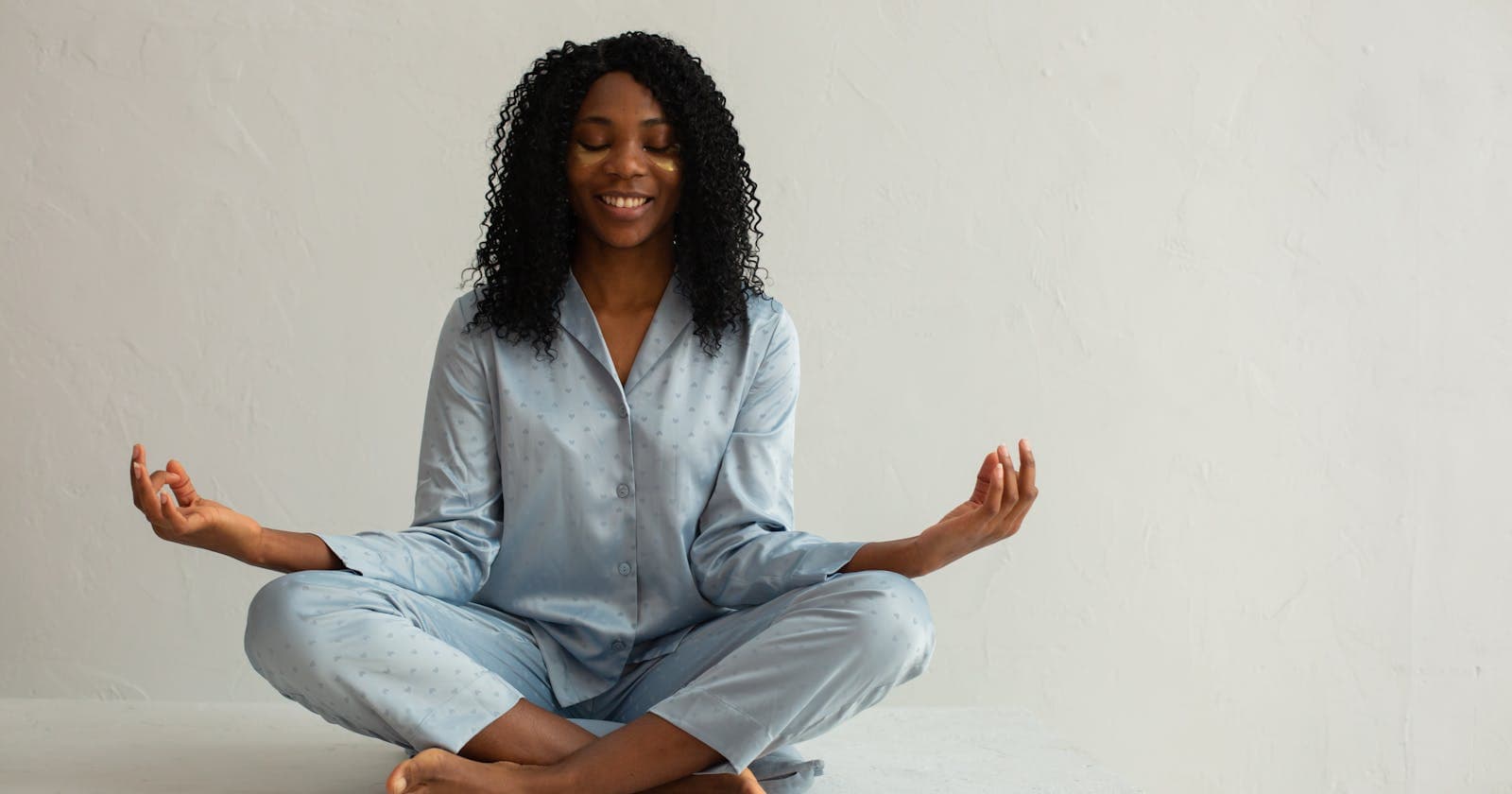 Woman in lotus pose, blue clothing — the humming bee breath in practice