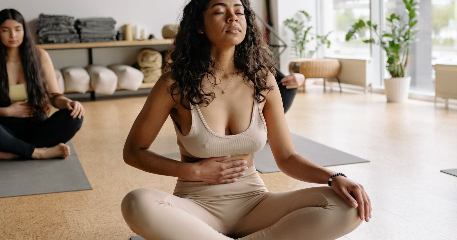 Woman on yoga mat with hand on belly — body scan as a daily check-in