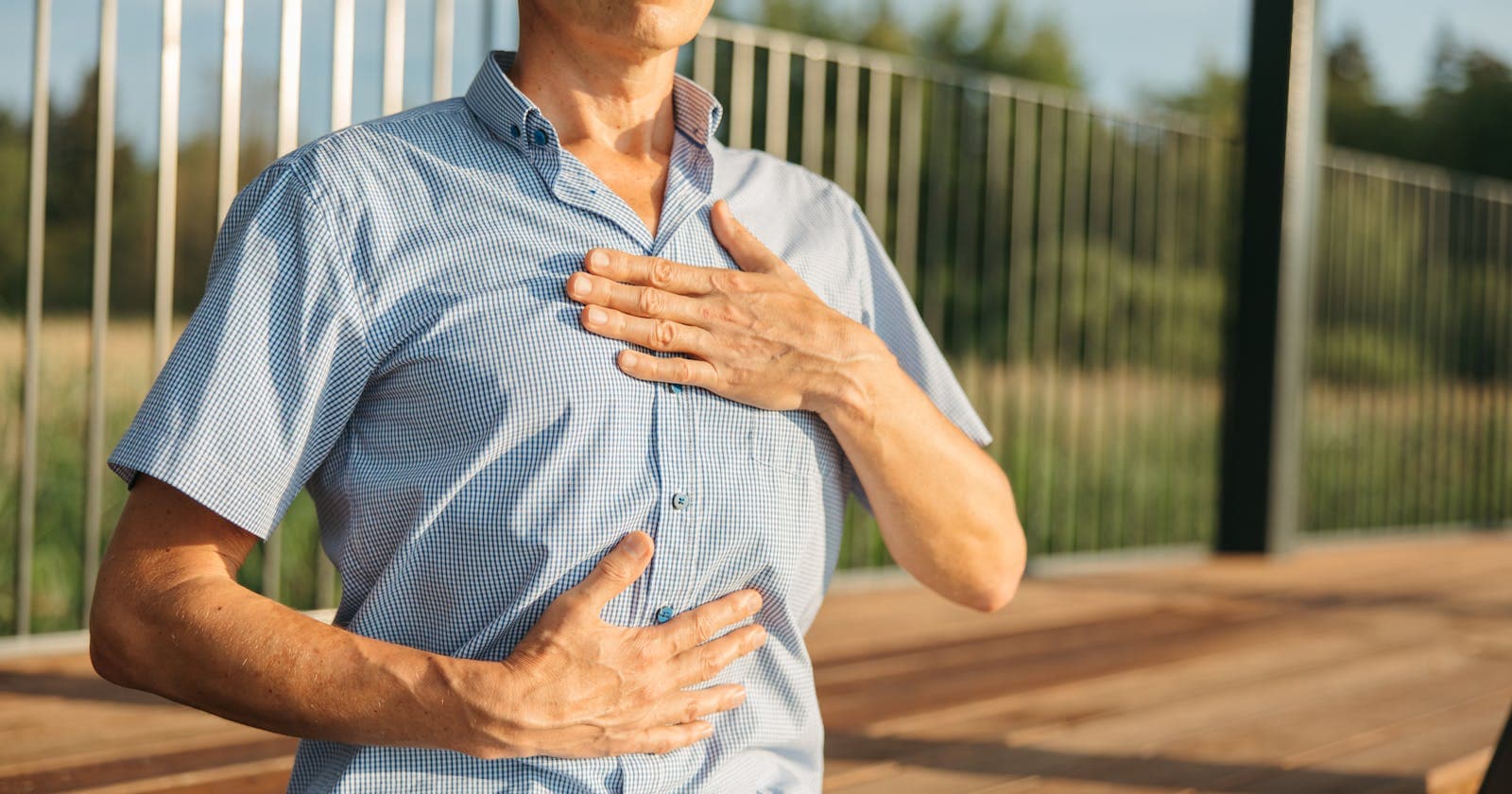 Hands resting on chest outdoors — the simple anchor of breath