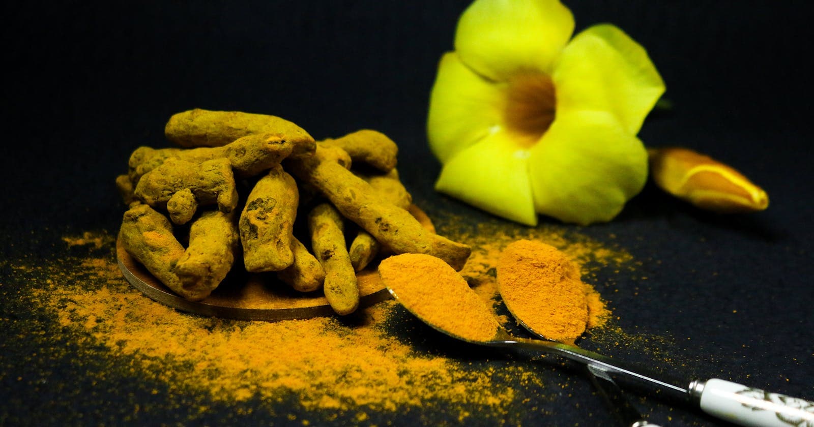 Turmeric roots and powder with flowers — anti-inflammatory eating starts here