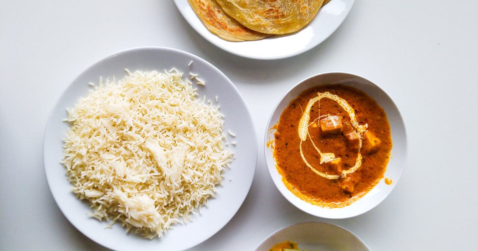 Spread of Indian dishes including paratha, curry, rice — eating by constitution, not calorie