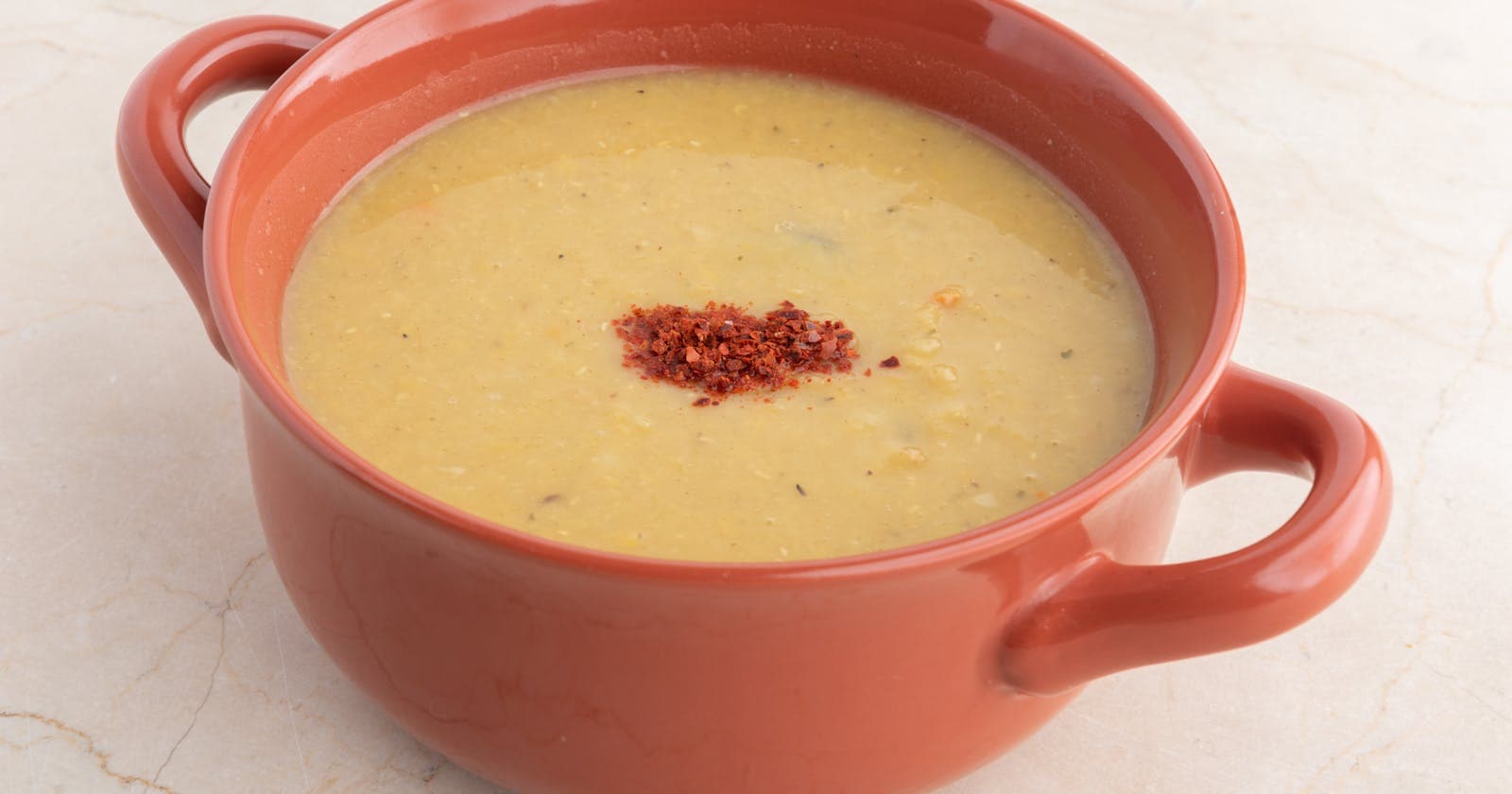 Warm bowl of lentil soup in terra cotta — kitchari, Ayurveda's one-pot meal