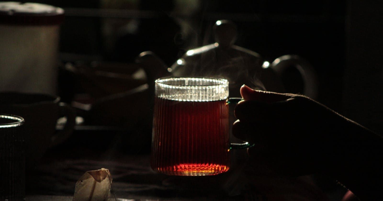 Steaming herbal tea cup in low light — evening routine, in one cup