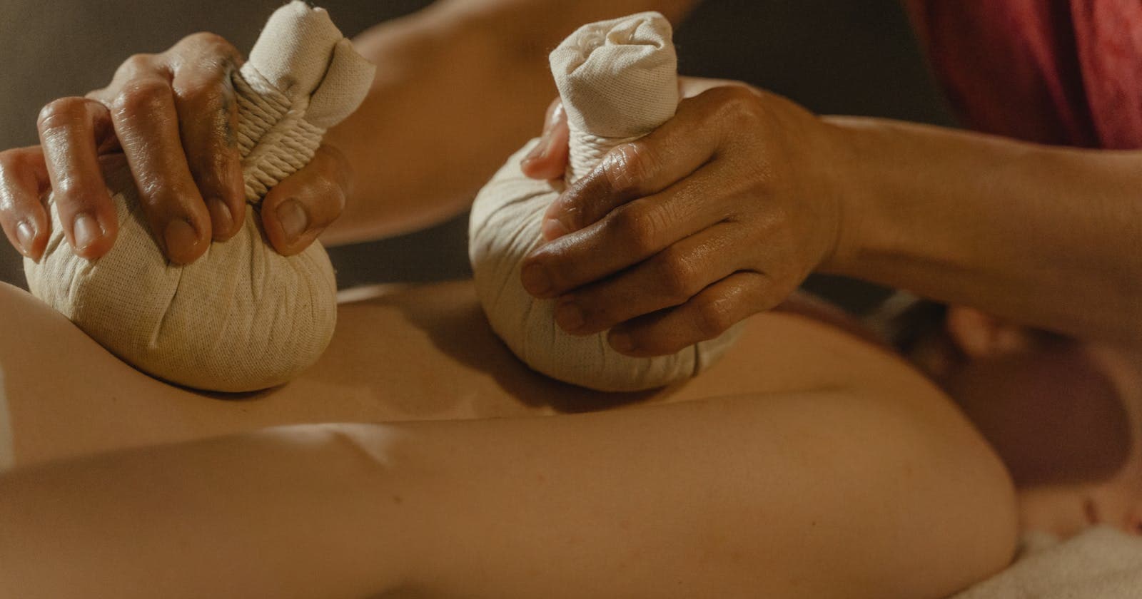 Person holding a warm herbal compress, the kind of joint care Ayurveda has used for centuries