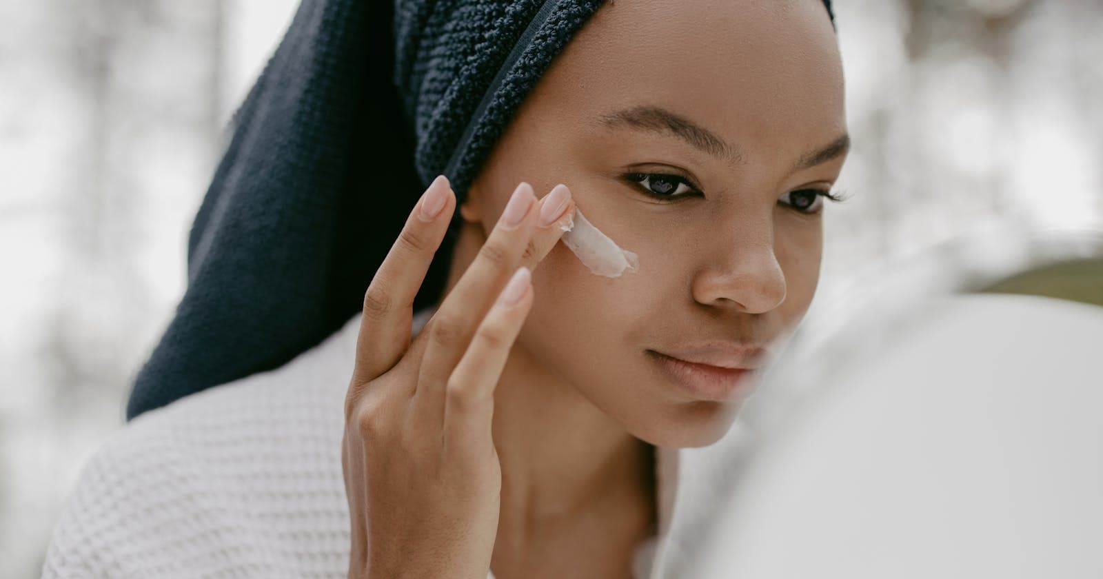 Woman gently applying facial cream, Ayurvedic skincare is about consistency, not products