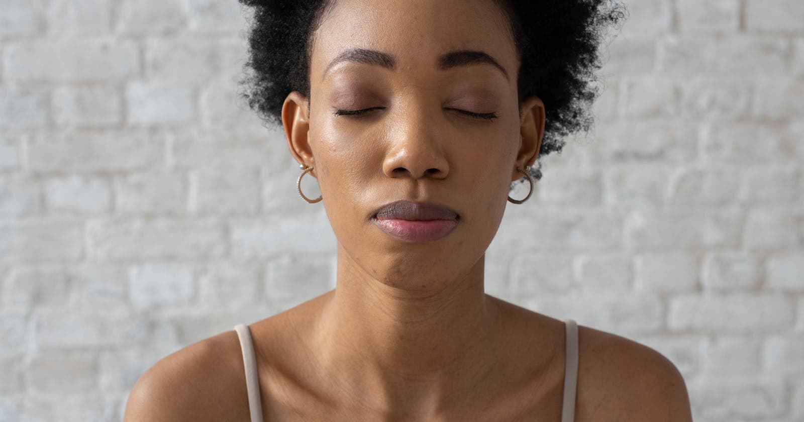 Woman meditating with eyes closed, Ayurveda's quiet approach to stress