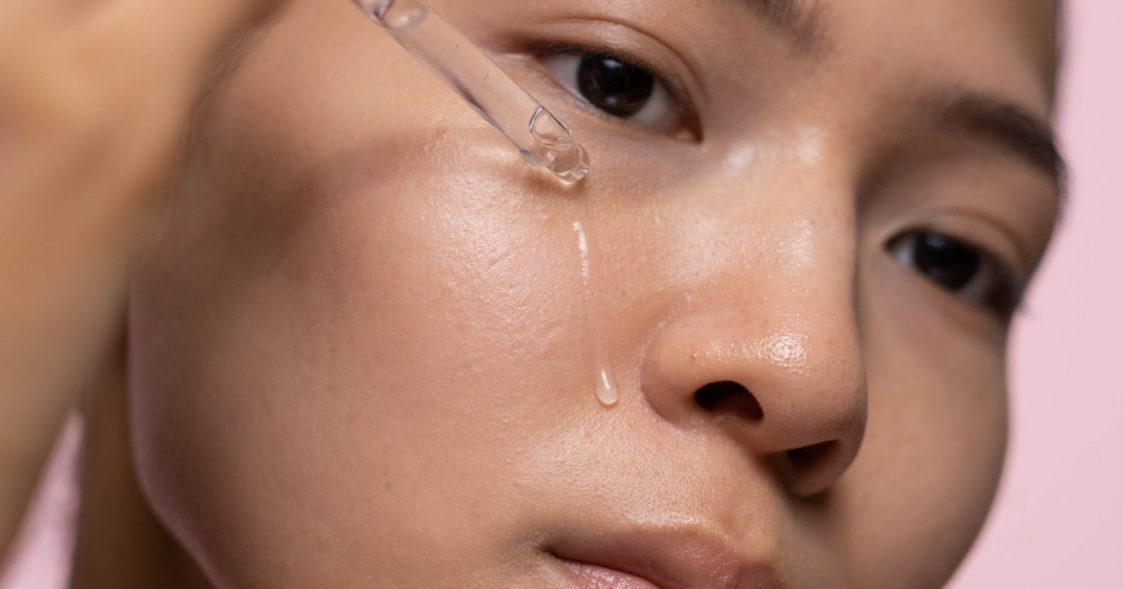 Skincare serum dropper held over the skin, the slow daily Ayurvedic routine